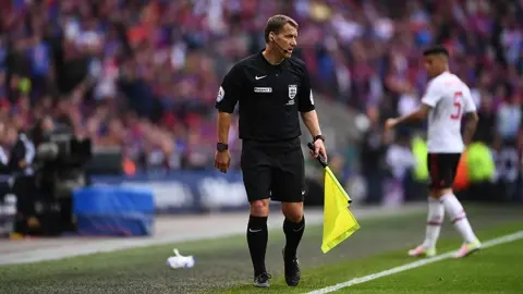 Phóng viên: Halliday sẽ hộ tống cúp FA Cup với tư cách một người lính. Ông cũng đã từng là trọng tài cuối cùng.