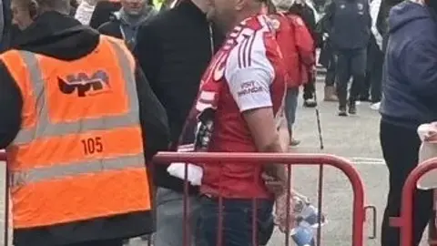 Đã đi đến tận Bournemouth! Fan Arsenal cầm ly nước Man City chờ xe buýt Man City