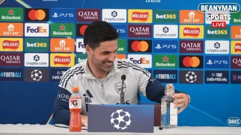 Quay lại và uống hai ly! Phóng viên đưa cho Arteta một chai đồ uống Mexico và Arteta vui vẻ nhận lấy